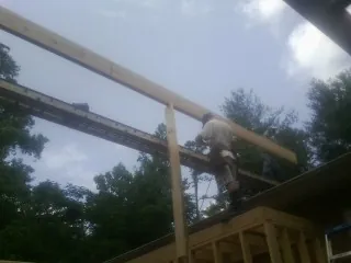 Carpenter setting a ridge beam over a new addition frame — Ice Dam Removal by Roofing Brothers in Unityville