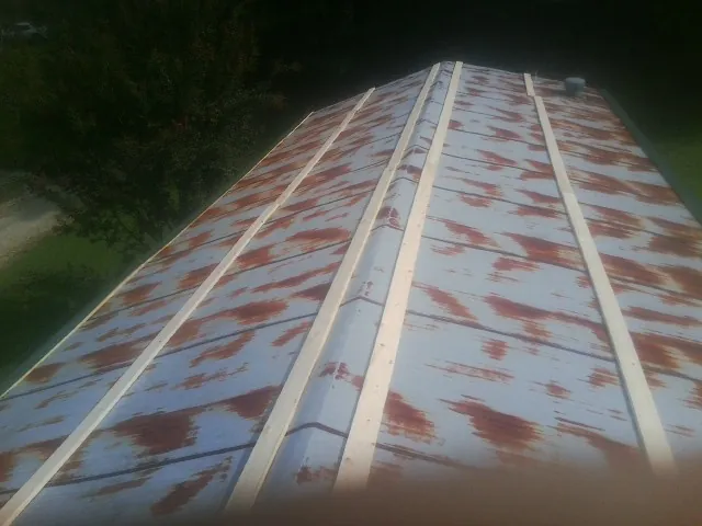 Rusted metal roof panels with new wood purlins before replacement — Storm Damage Roof Repair in Unityville by Roofing Brothers