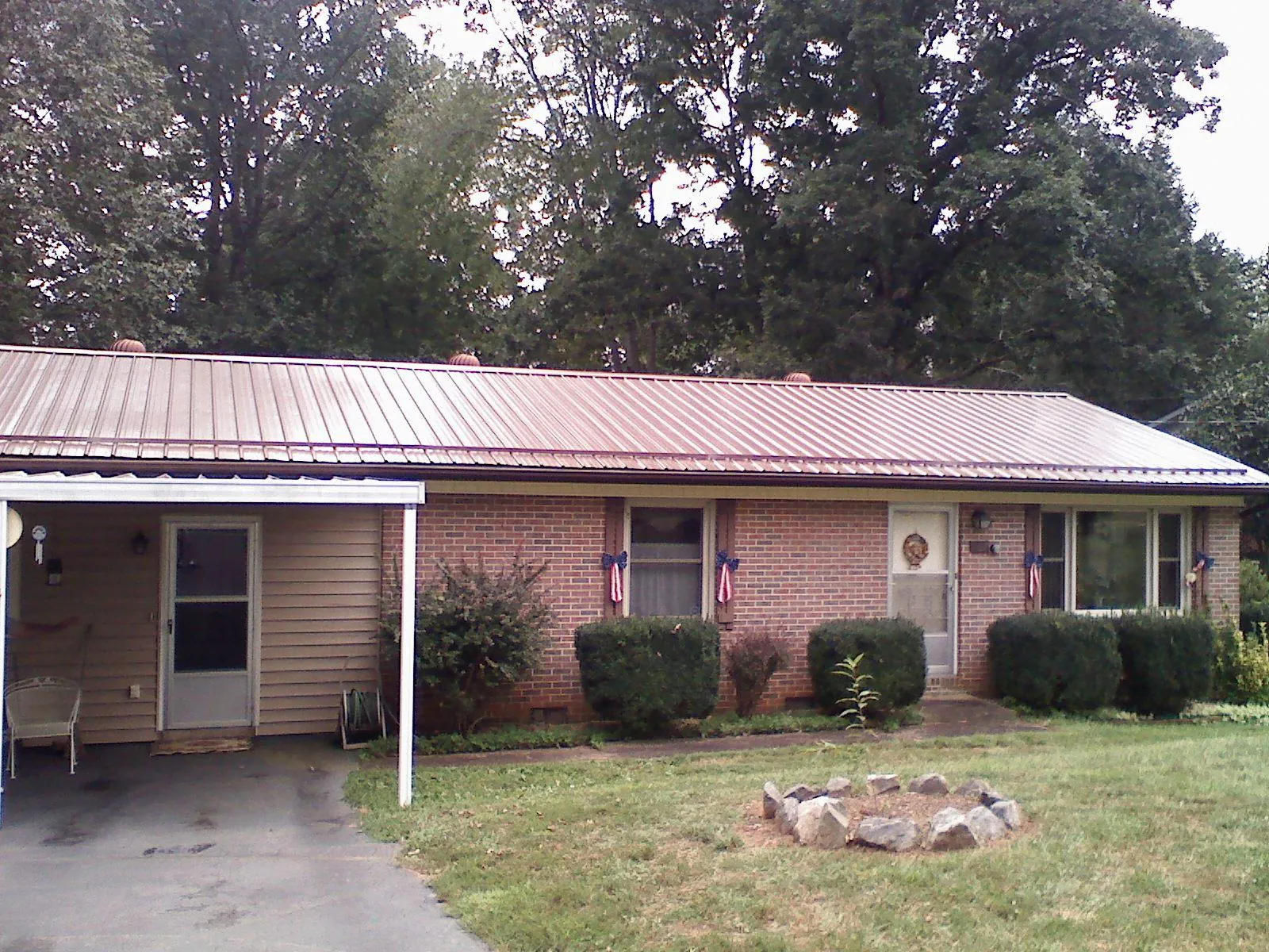 Bronze metal roof and carport on a brick ranch home — Roof Repair work by our crew in Unityville