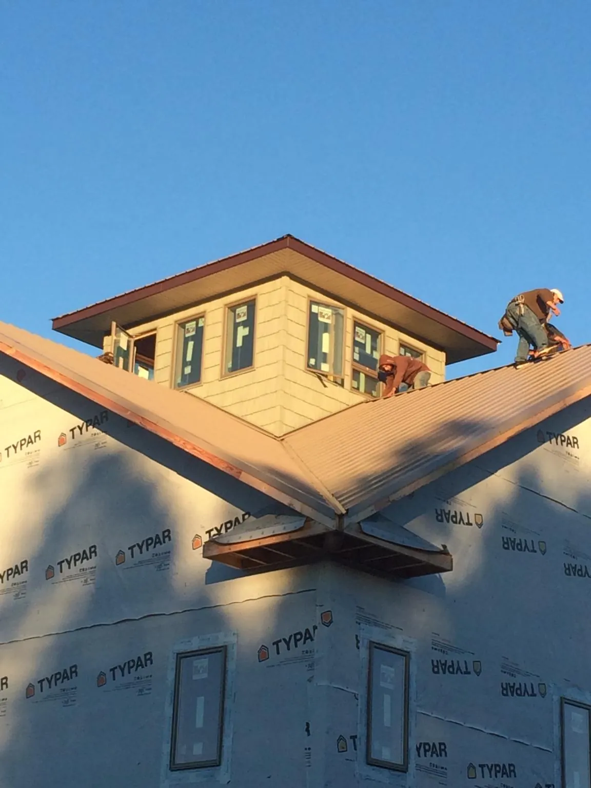 Roofers working around a rooftop cupola on a new metal roof at sunset — Roof Waterproofing in Unityville by Roofing Brothers